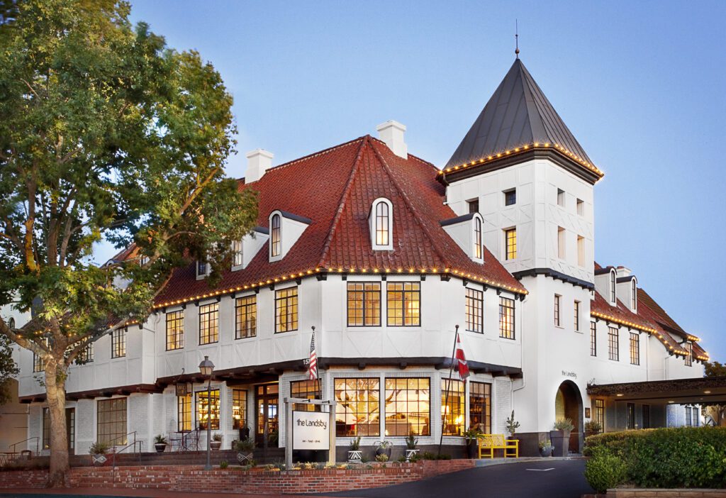 Danish styled exterior of the hotel with red tile roof, several windows and a tower