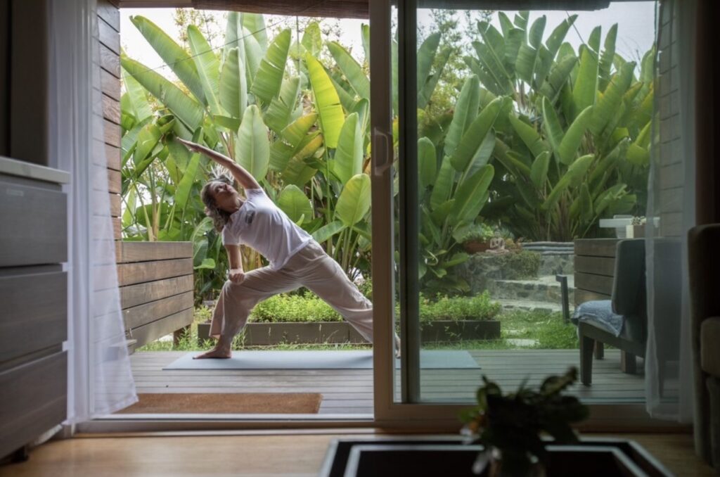 Woman doing yoga on a private deck of a guest room at the Inn at Moonlight Beach