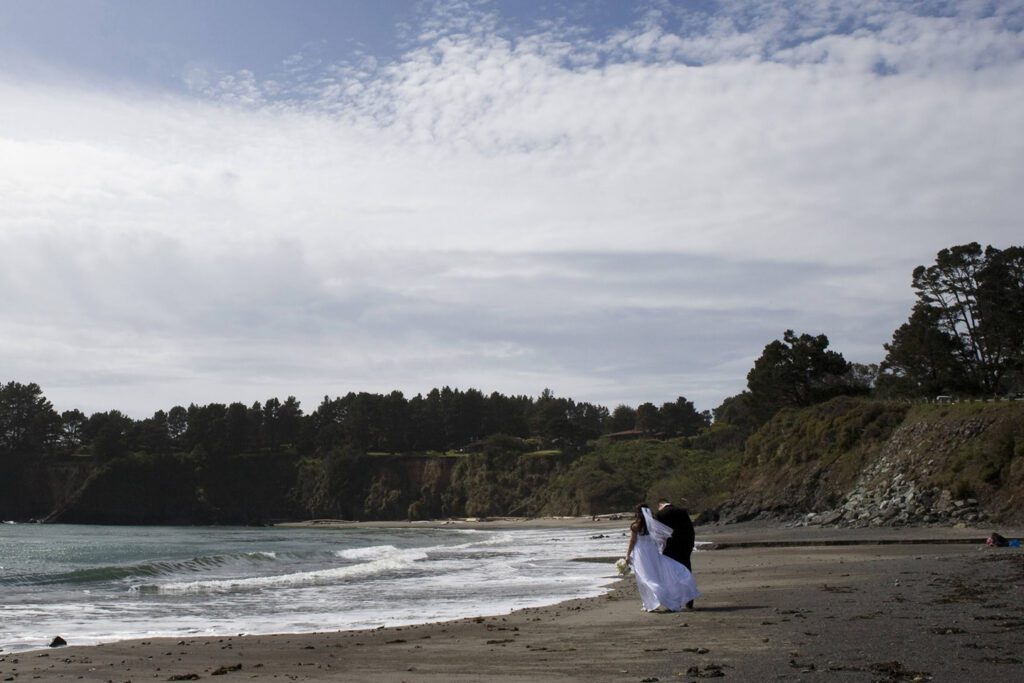 Bride and groom walking on a beach 