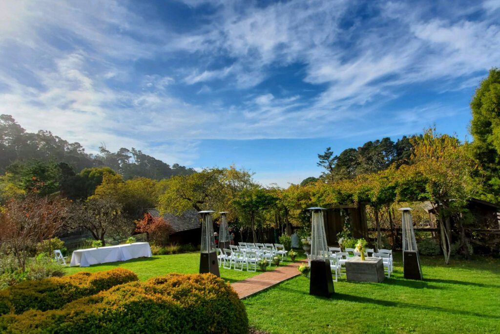 A verdant garden set up for a wedding with a dramatic blue sky overhead