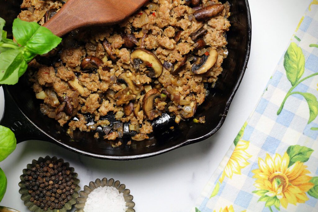 Sauté the vegetables and sausage until the sausage browns.