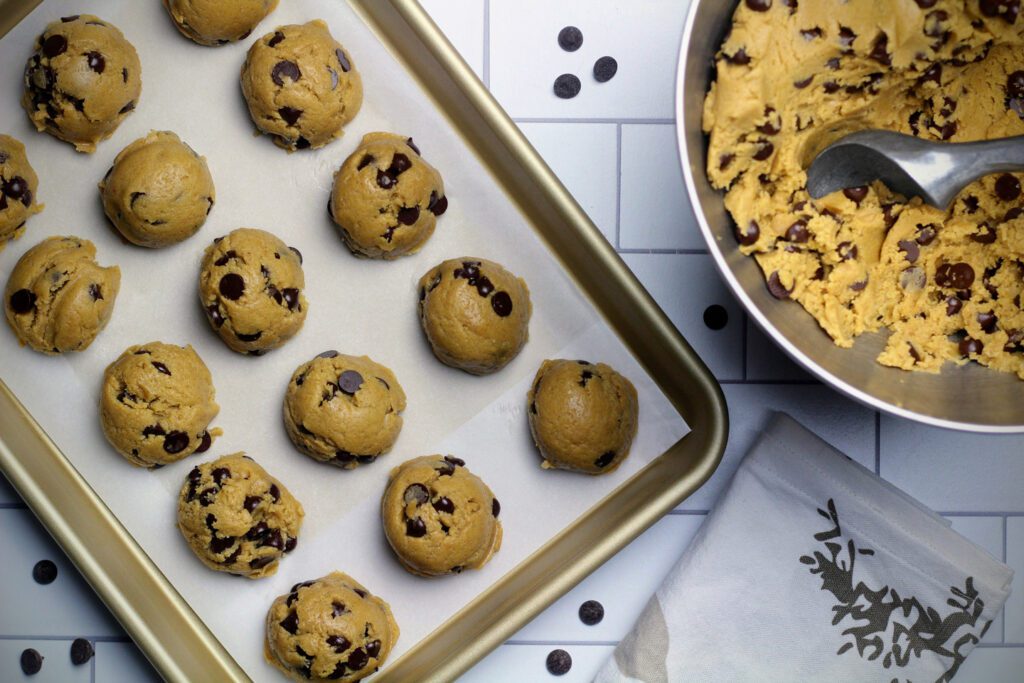 Chocolate chip cookie dough scooped onto a baking sheet