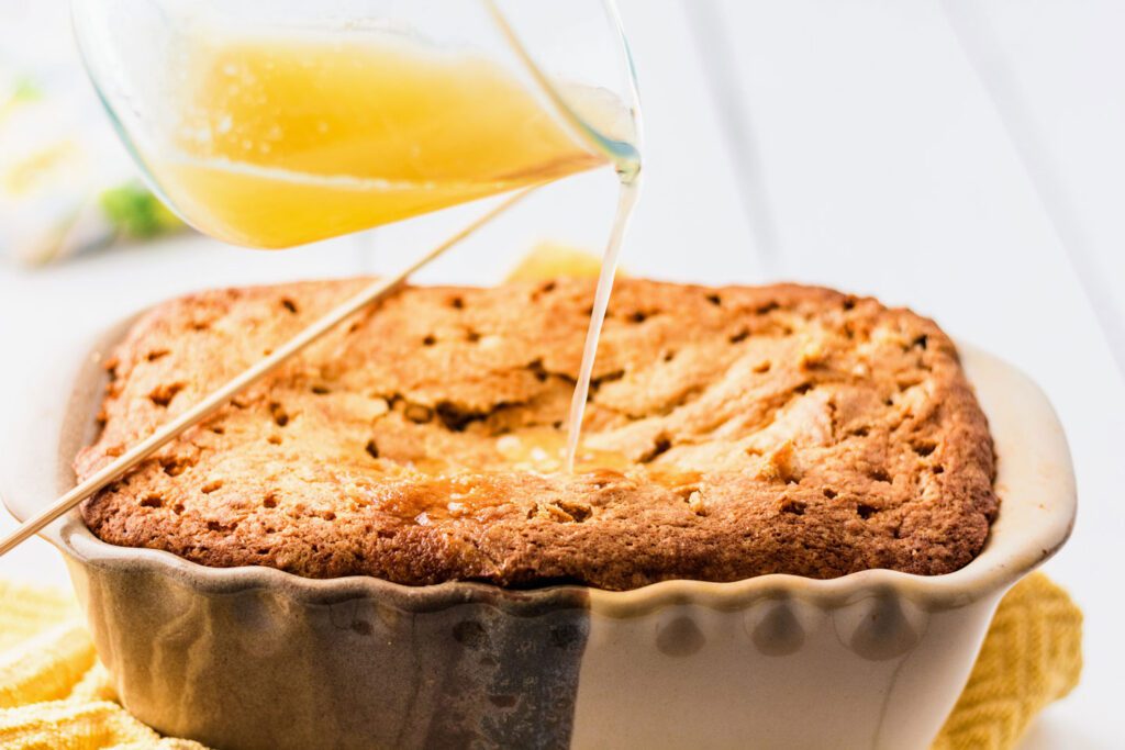 Pouring the lemon topping onto the baked lemon bread.