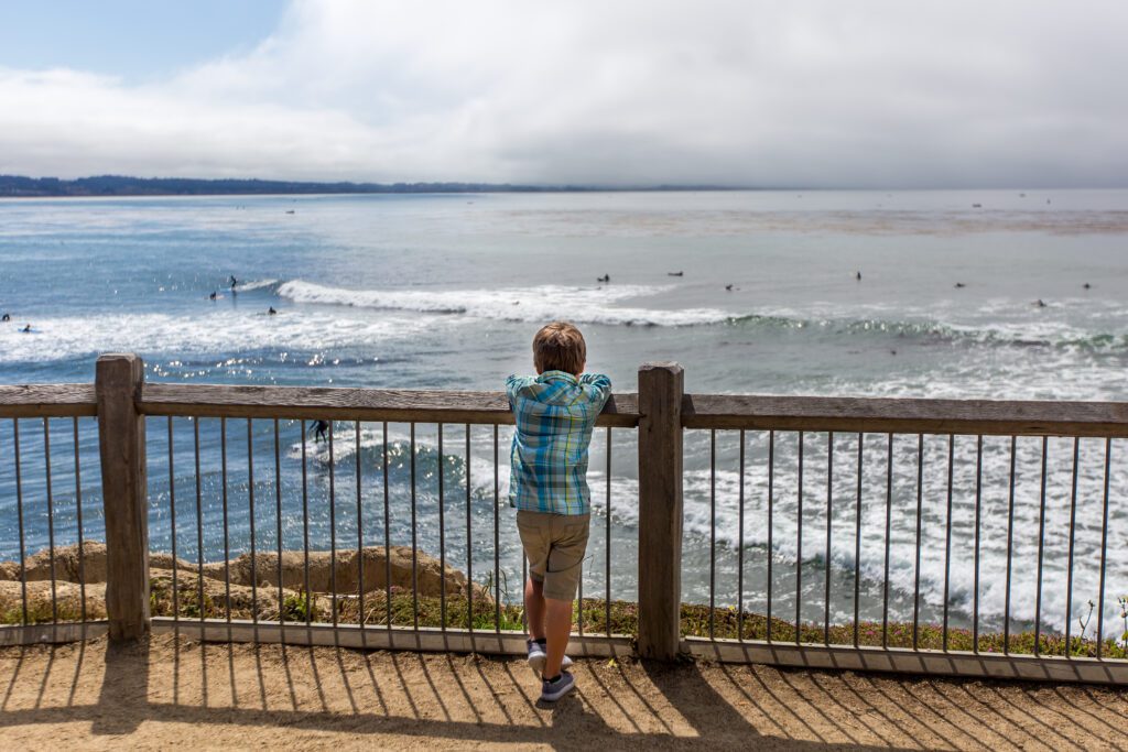 A young boy watching surfers from East Cliff Drive