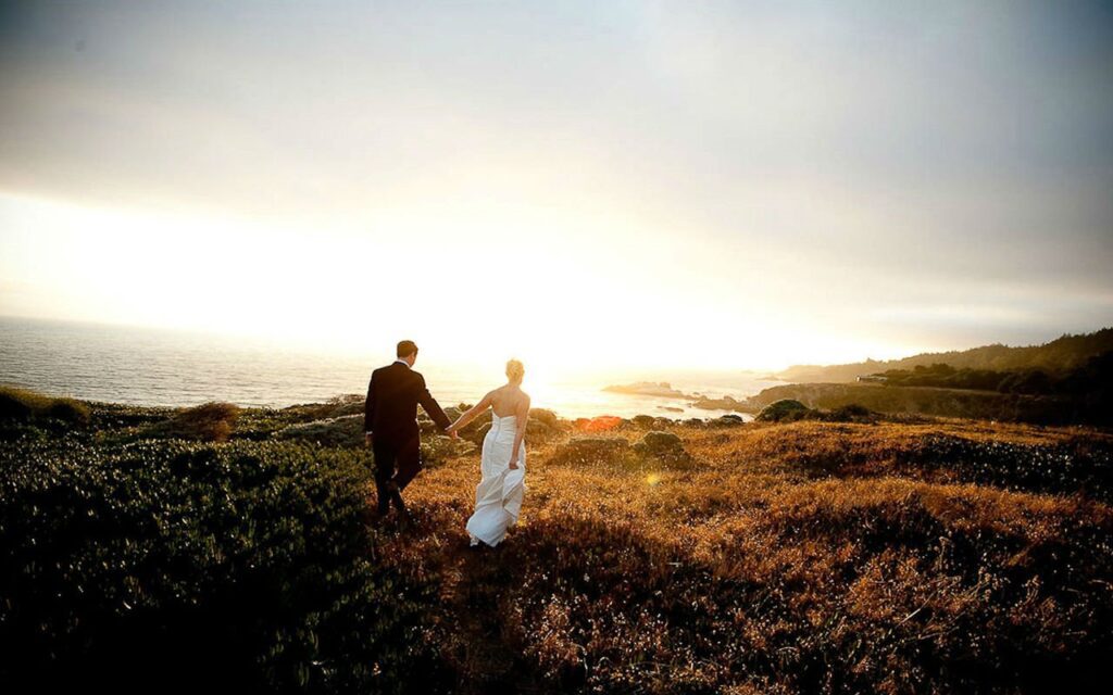 Bridge and groom on the ocean bluffs at Timber Cove Resort at sunset