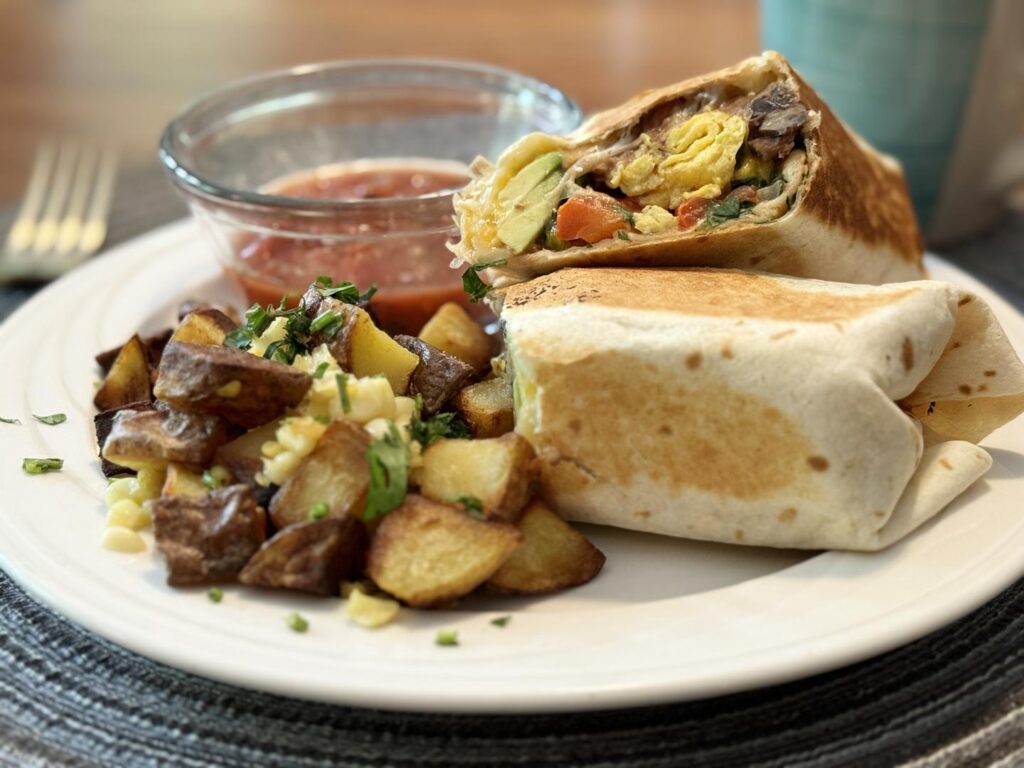 A breakfast burrito with roasted potatoes and salsa