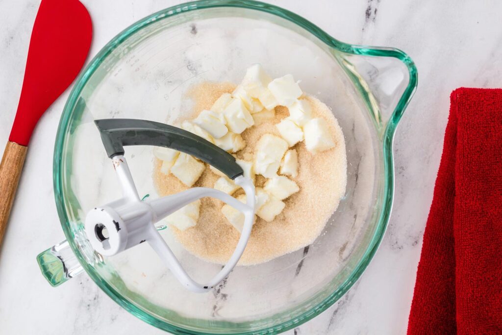 Sugar and chunks of butter in a glass mixixng bowl
