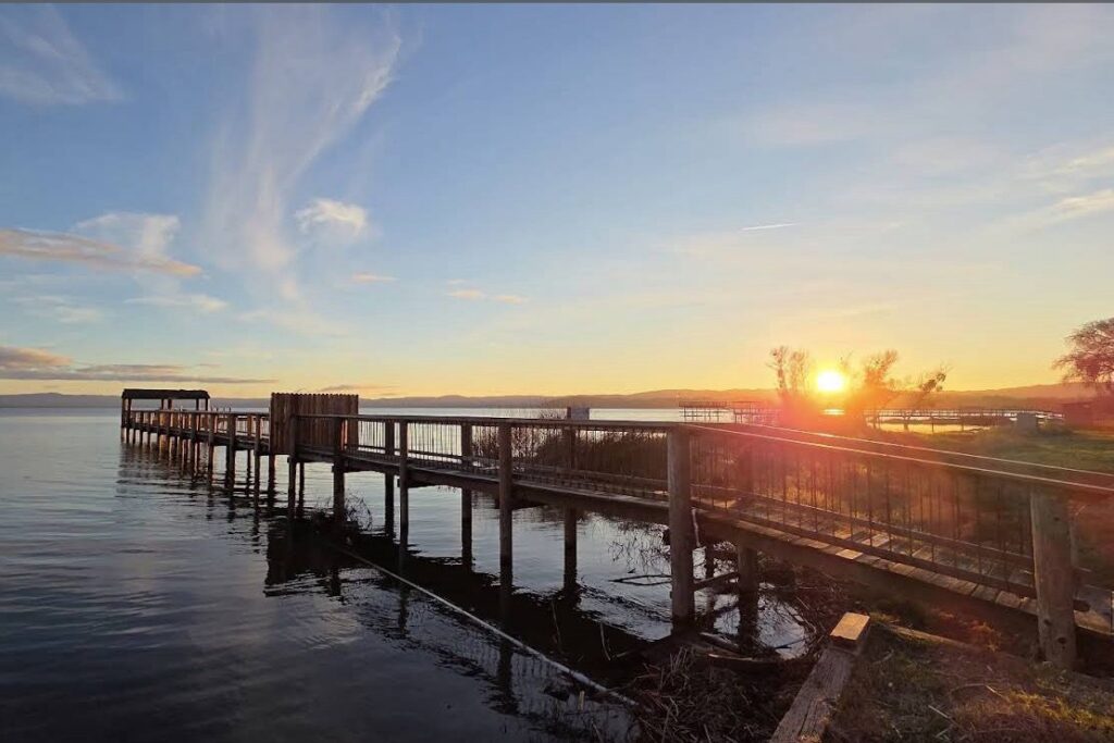 Dock extending out into a lake at sunset