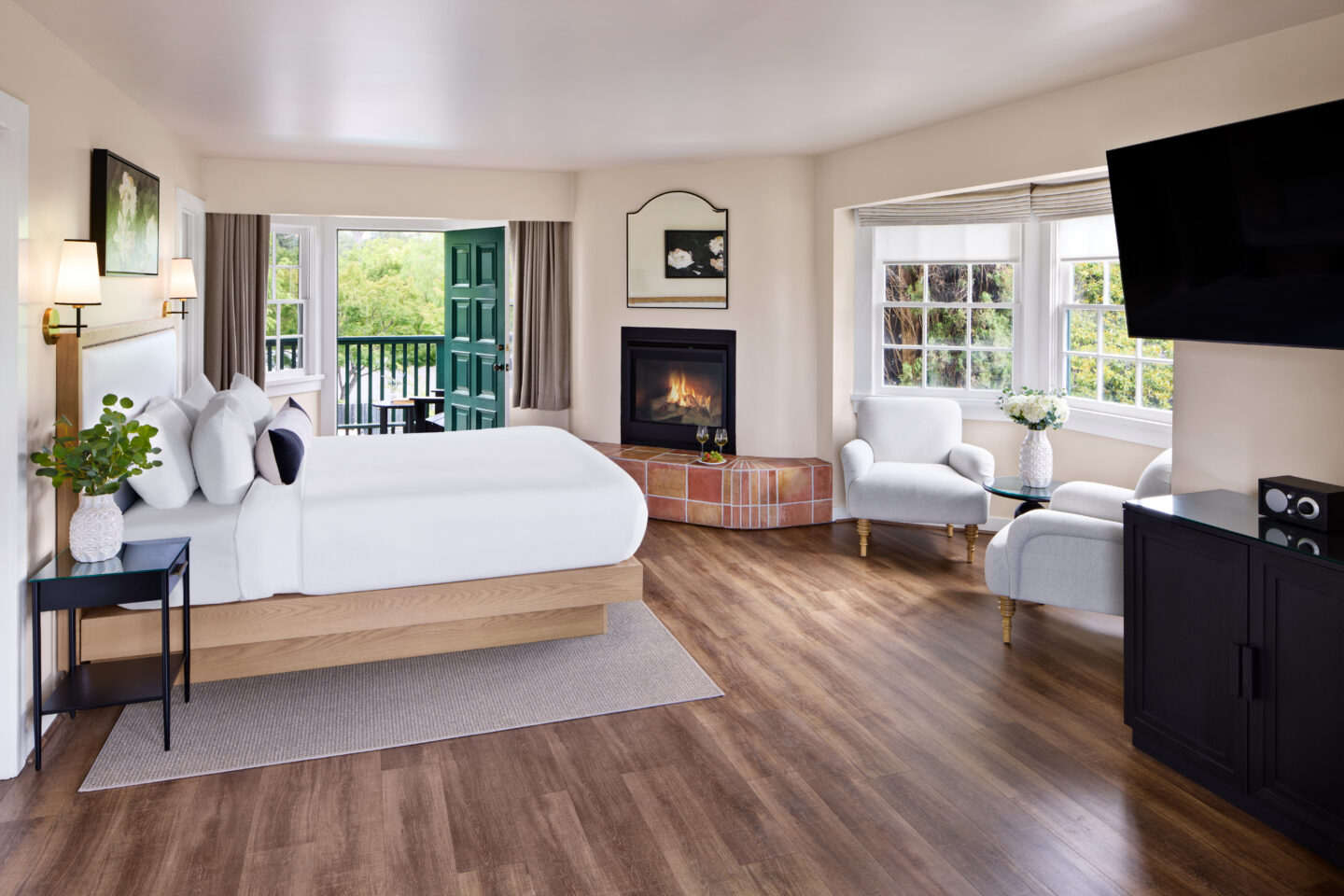 Guest room with a corner fireplace, bay window, and contemporary furnishings.