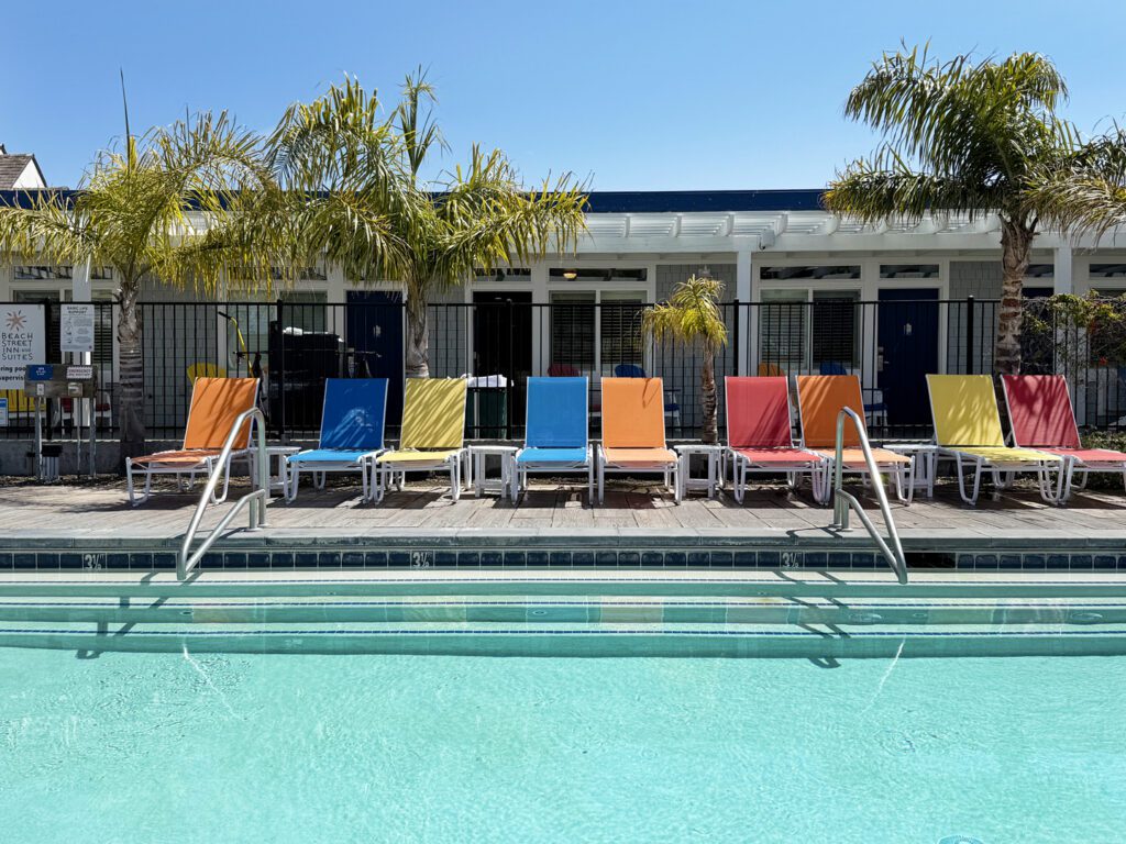colorful lounge chairs lining the edge of a swimming pool