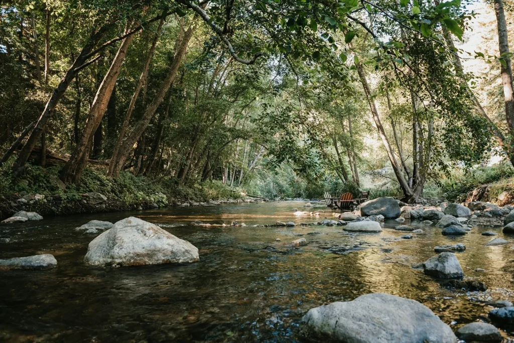 Adirondack chairs in the river at Big Sur River Inn