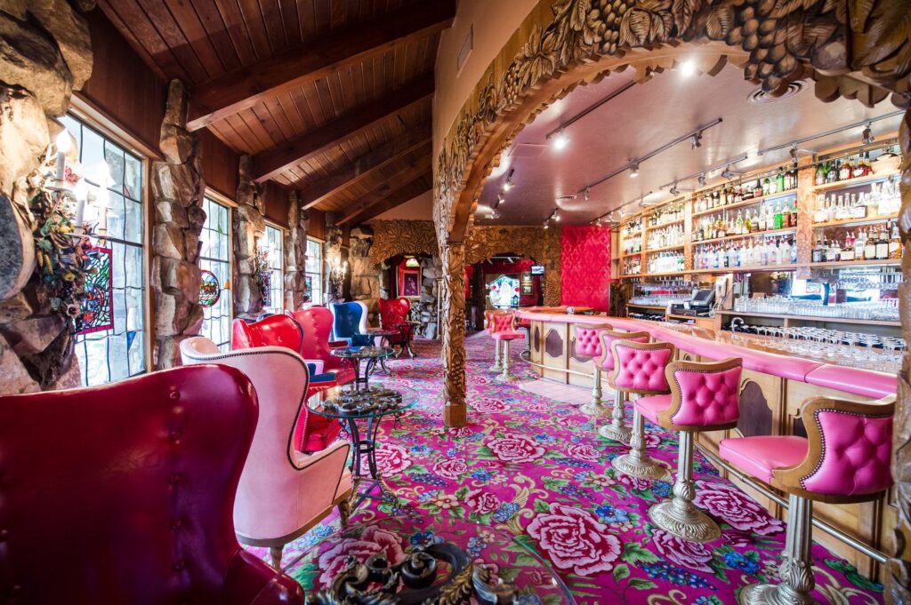 Lavish lounge and bar with hot pink chairs and carpeting