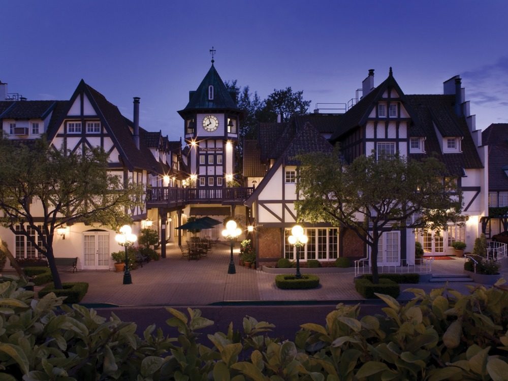Half-timbered hotel at night with a clock tower