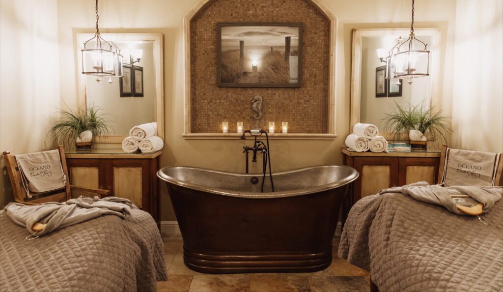 a couple's massage room with a copper soaking tub